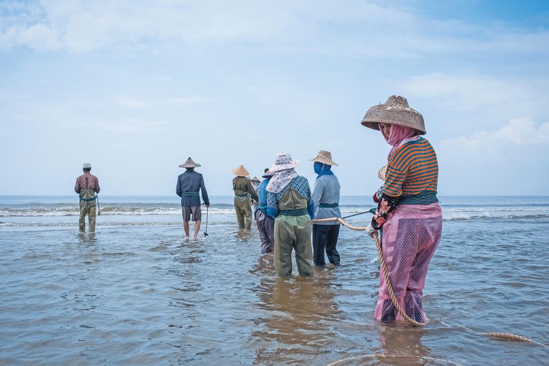 Locals in Chaozhou demonstrate a traditional fishing method by pulling in nets together