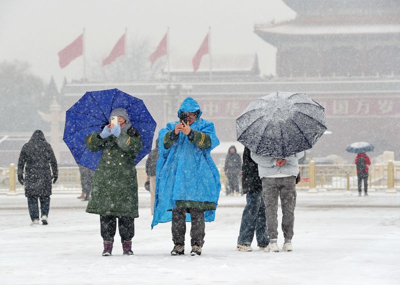 Tourists in Tian'anmen Square during snowy day