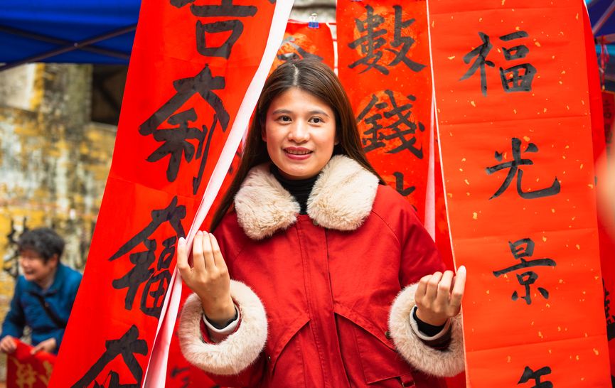 Tourist poses with New Year calligraphy in China