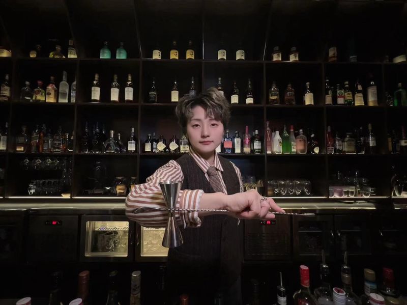 Zhou Xiaoyan posing at a bar