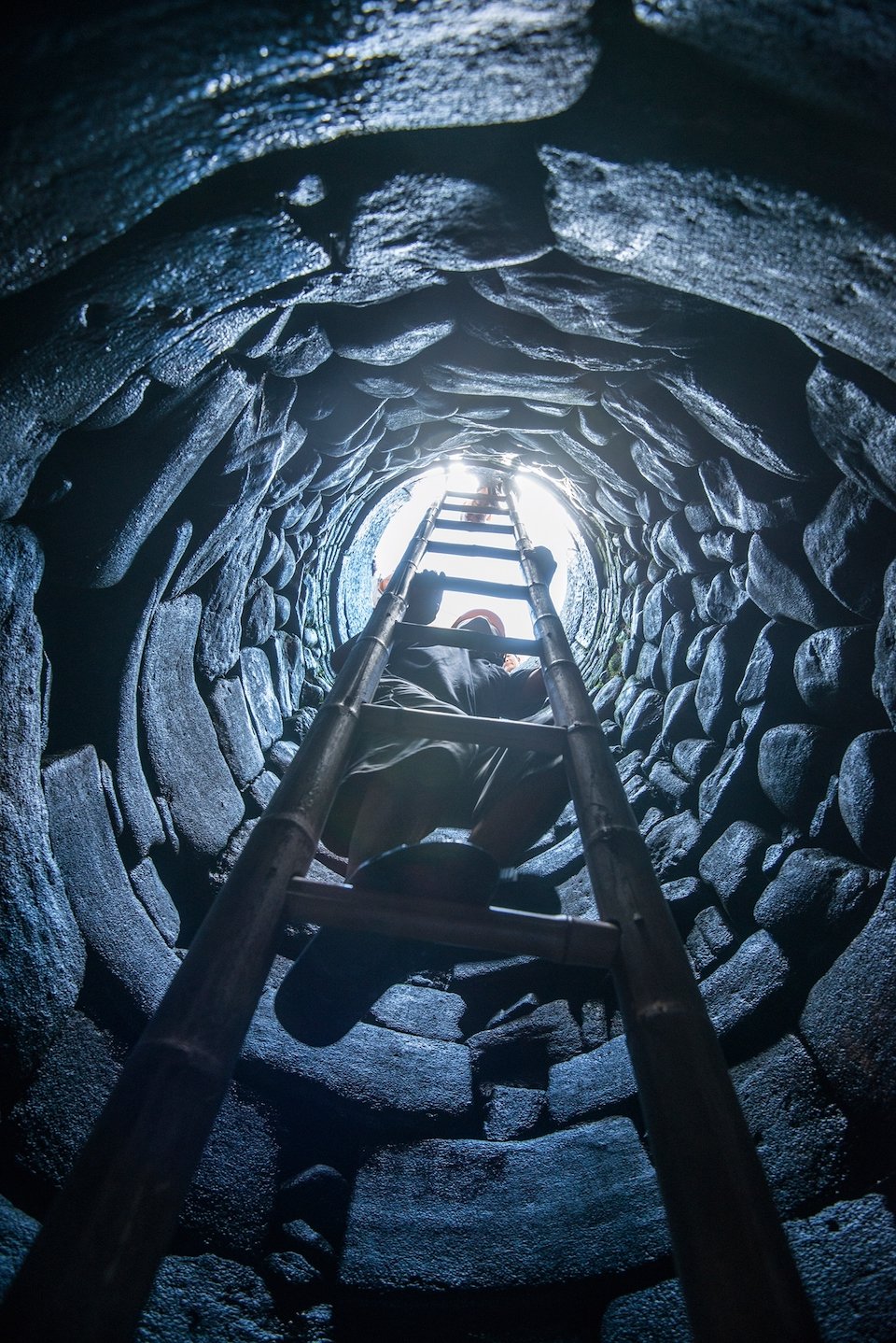 Able-bodied villagers are tasked with climbing down to clear rocks and weeds at the bottom of the well