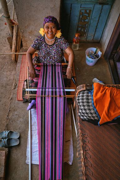 A Wa woman hand-weaves a purple brocade