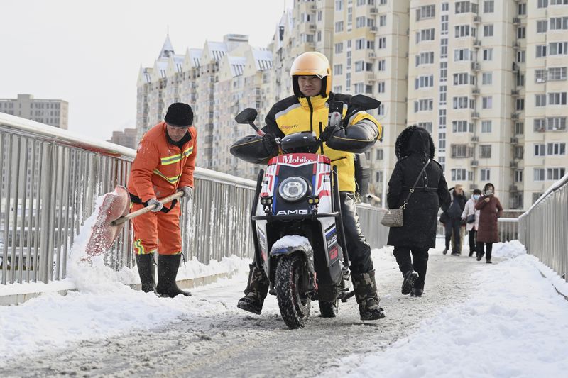 A delivery drive riding a motorcycle on a icy road