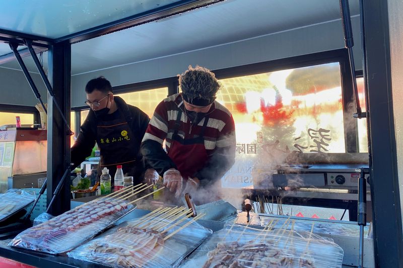 A street barbecue stall serves hungry skiers inside a ski resort in Zhangjiakou (Shao Yefan)