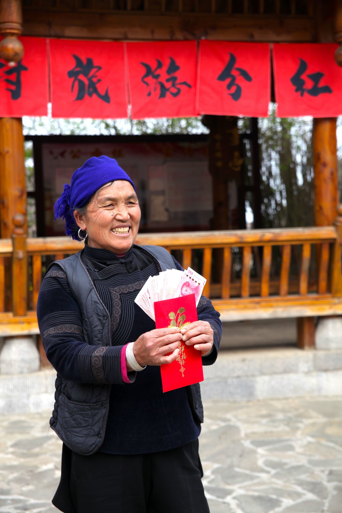 Azheke villager showcasing her 8,000 yuan dividend payment in the village square