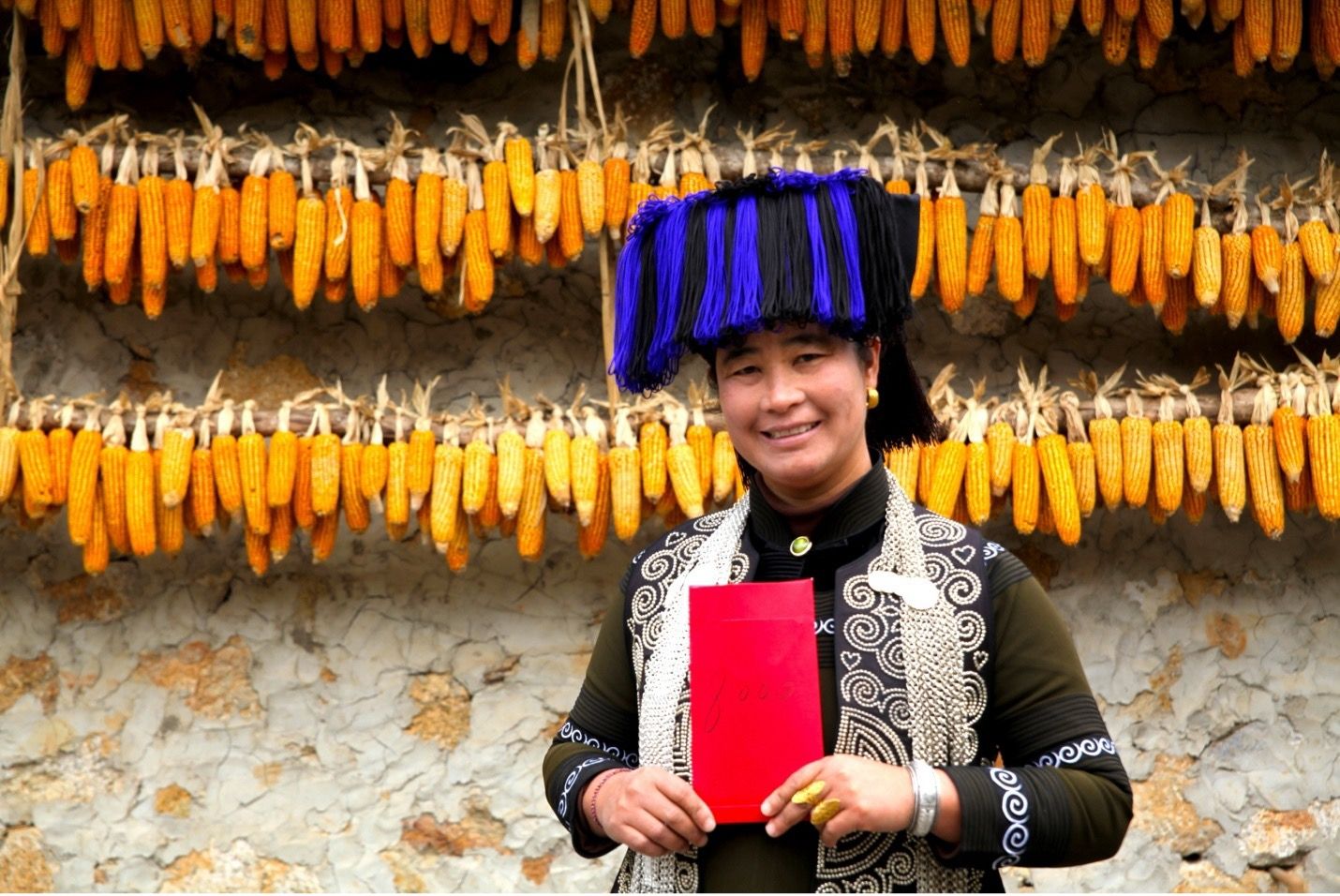 Azhke villager Gao Meihua with the 8000 yuan hongbao she received from the 11th dividend payment