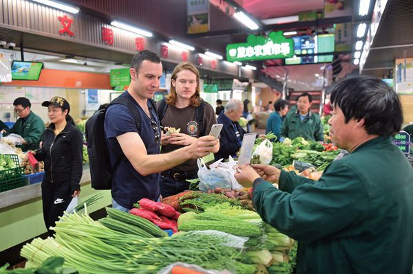 Foreigners are becoming used to cashless payment as well, as two shoppers use their phone to make purchases in Hangzhou. 