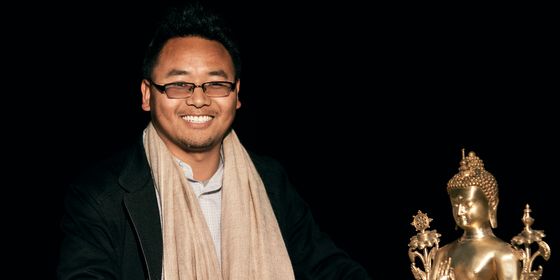 Headmaster Yeshi Tenzin with a golden Buddha