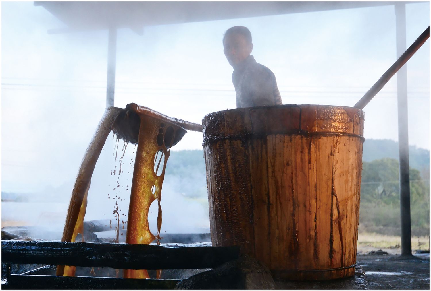 Workers must quickly ladle the juice so that no portion overheats in the pot