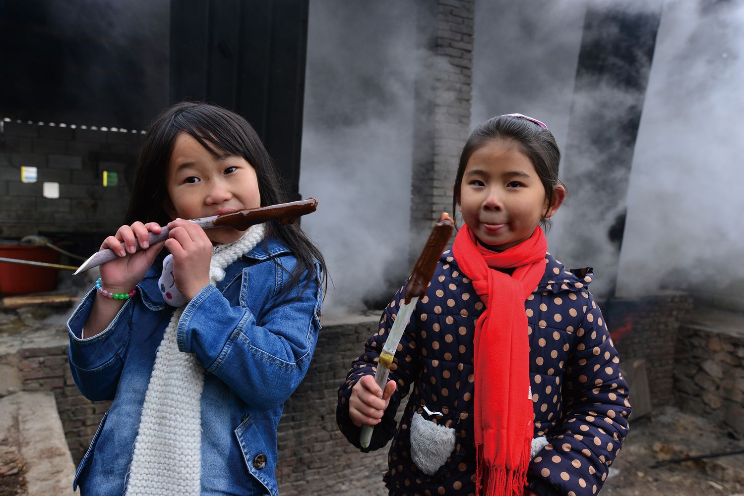 Children warming themselves by the sugar shack can often get a treat from the workers