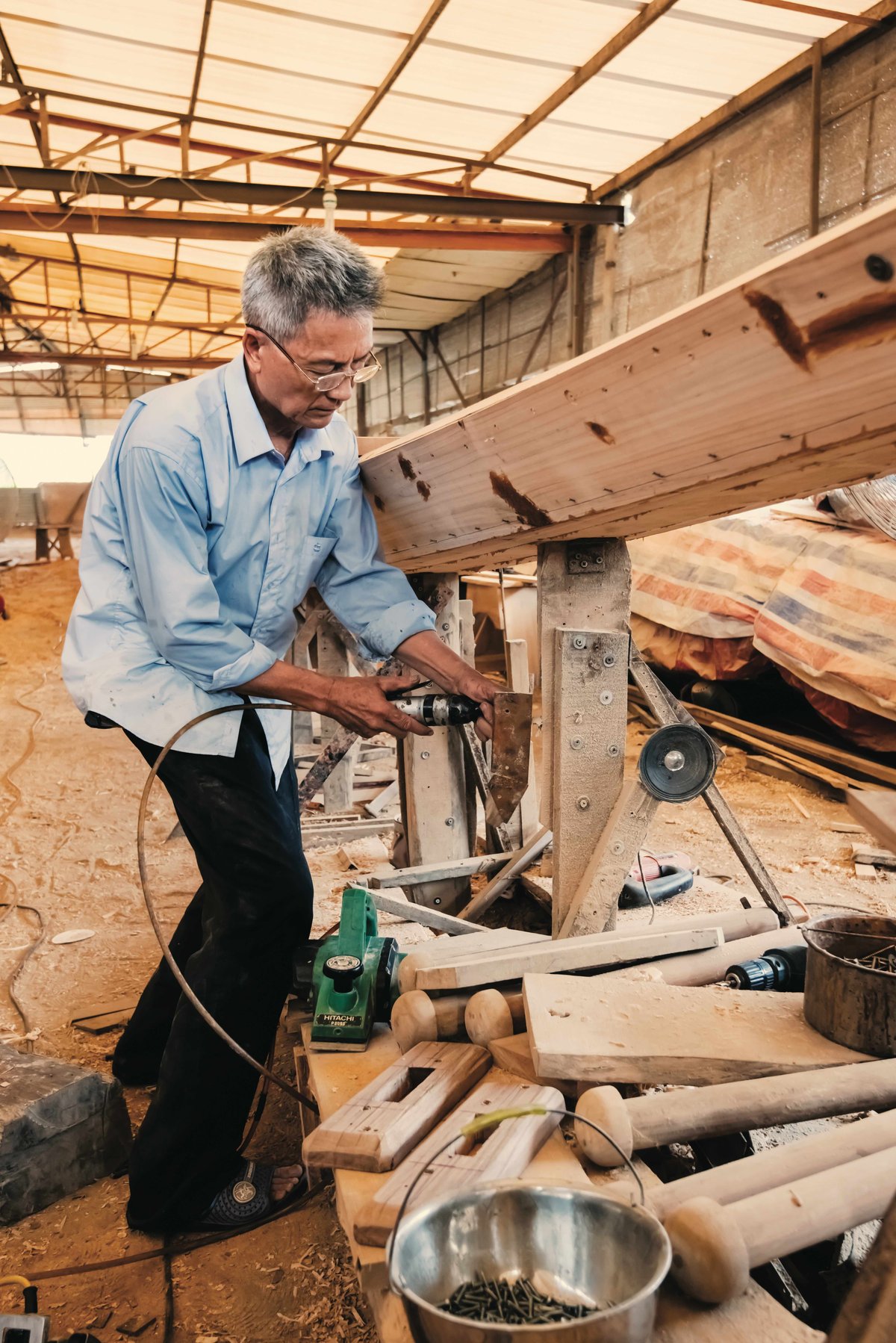 Guan Qunsu assembles some of the smaller parts for the dragon boat