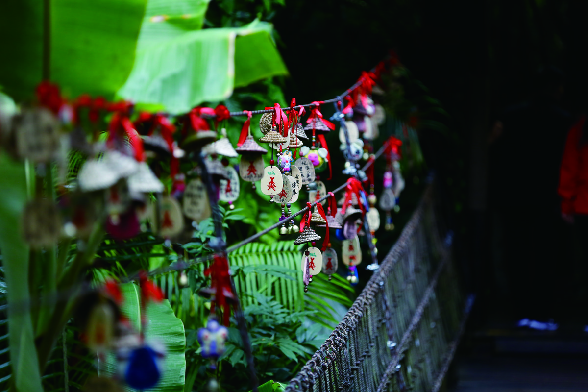 Visitors write their wishes on charms and tie them along the suspension bridge railings at Yanoda for good luck