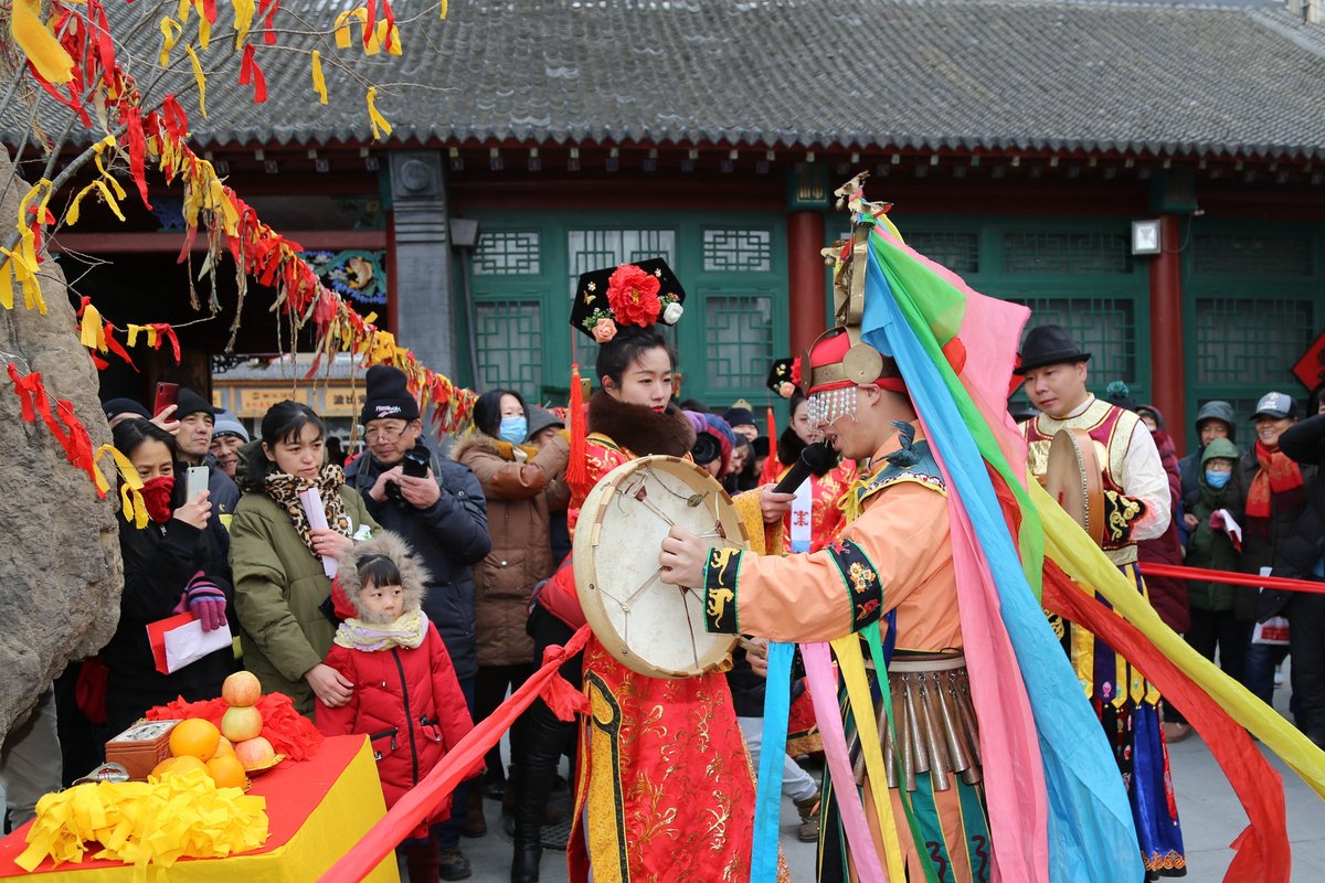 A shaman performing a ritual surrounded by tourists