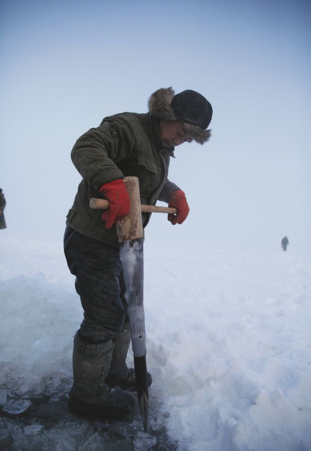 A traditional ice pick is pounded to drill a hole in the ice