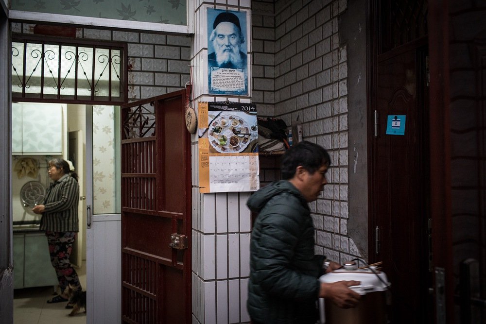 Portraits of Jewish elders hung from the wall pillars at Jin Jin’s family home courtyard