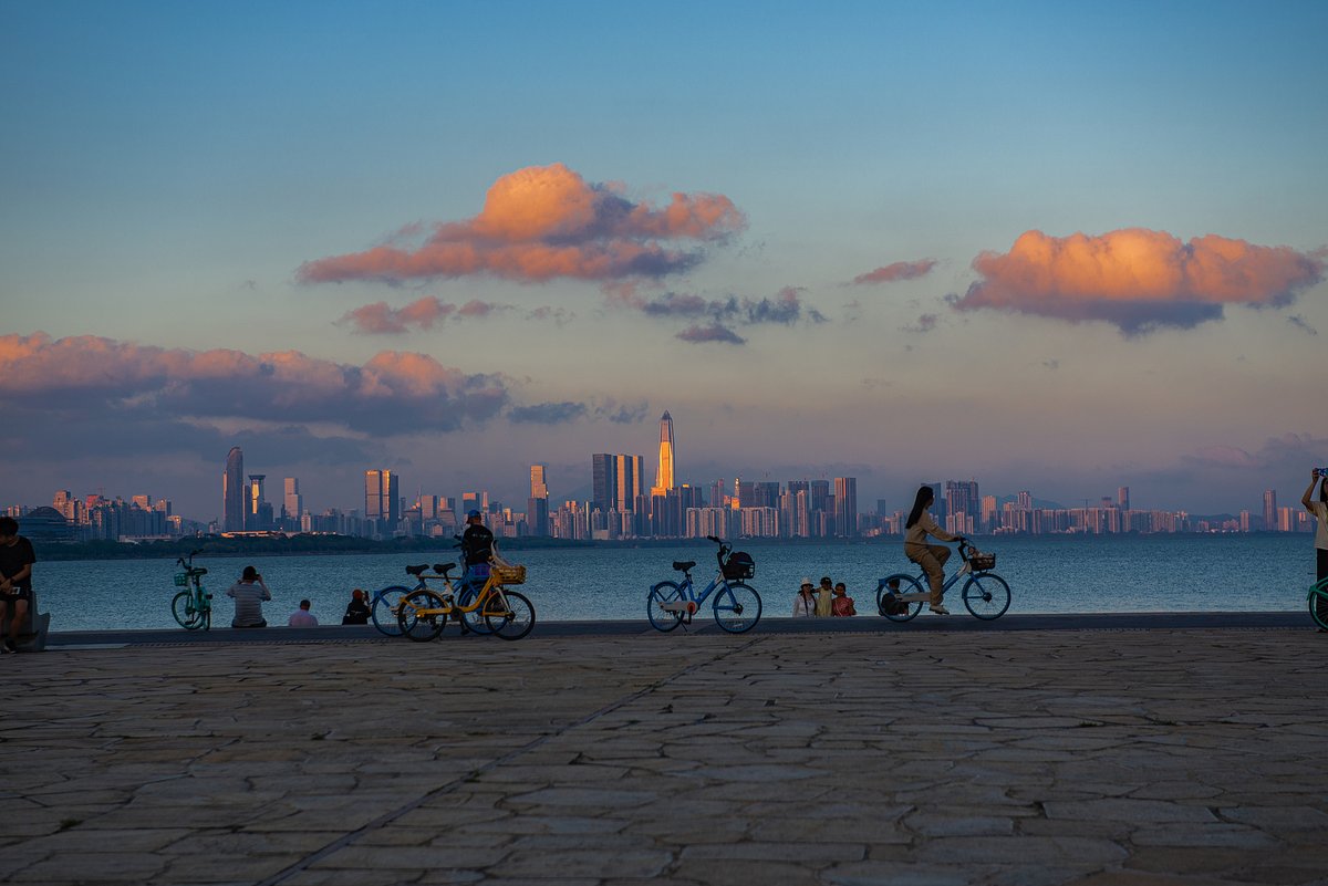 Locals bike around a park and enjoy the Shenzhen Sunset