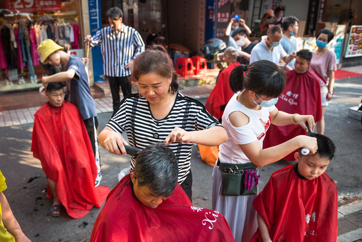 A team of street barbers offers 10-yuan haircuts on the streets of Guangzhou, Guangdong province. (2020)