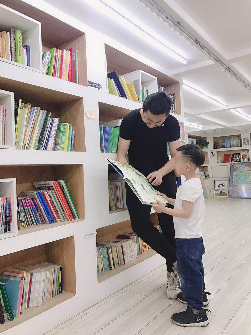 The Chinese boy who wore a skirt to school reads a book with his father