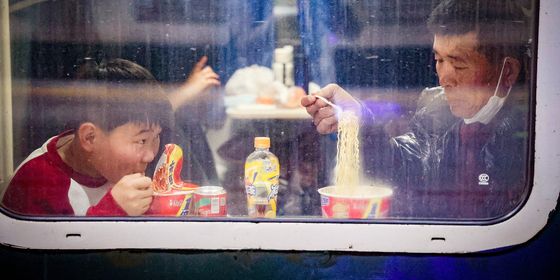 Spring Festival 2025_travelers eating instant noodles train_VCG111542124462