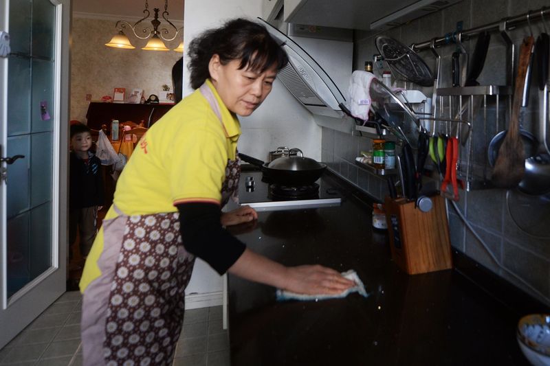 A Beijing nanny doing housework: Live-in nannies are typically hired to take care of children for working parents, as well as cooking and cleaning the home