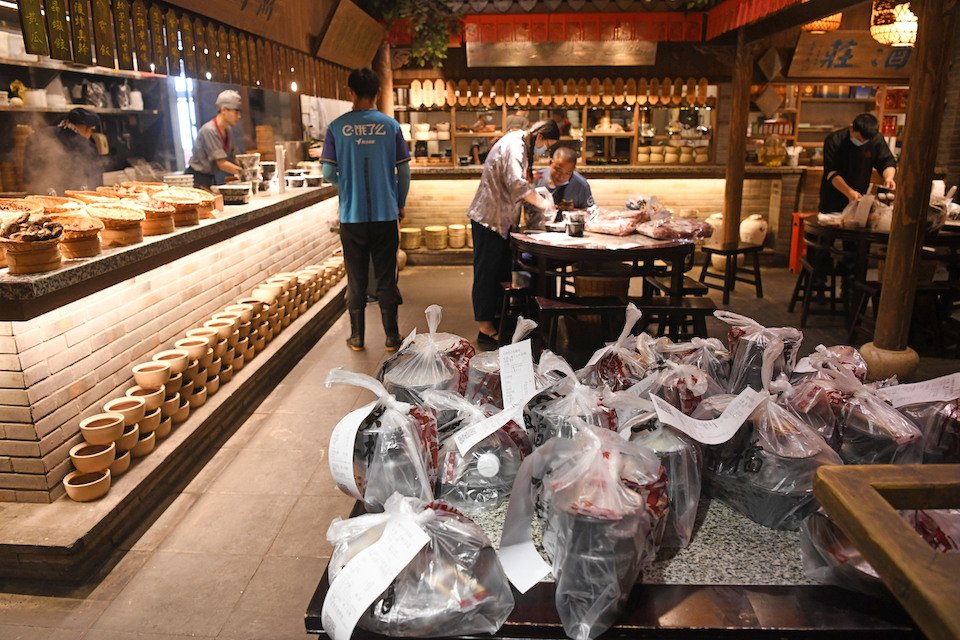 A Chinese delivery food driver waits for the restaurant to prepare a takeout meal