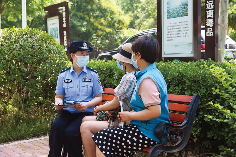 A policewoman and a social worker (right) having a routine meeting with a former drug user in Jinan, Shandong province