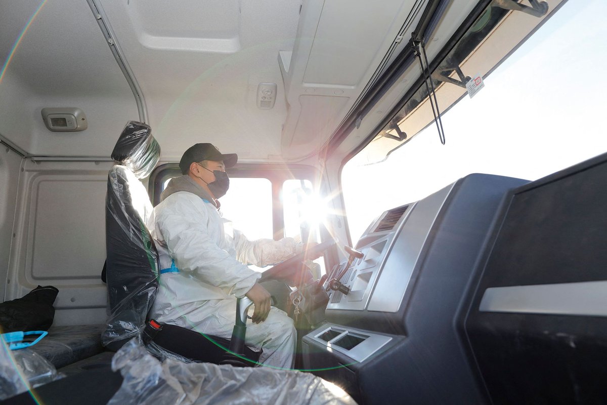 Cargo truck driver driving while wearing a mask