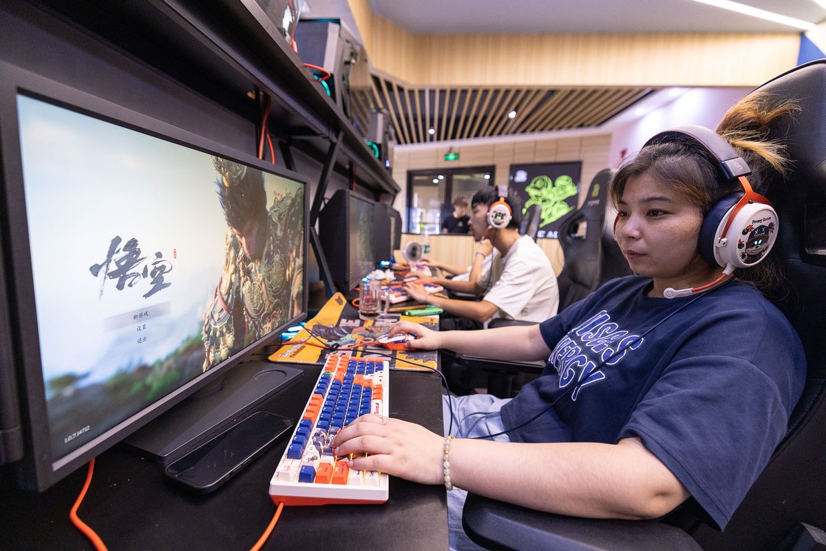 Chinese female gamer playing Black Myth: Wukong at a gaming cafe in Hangzhou