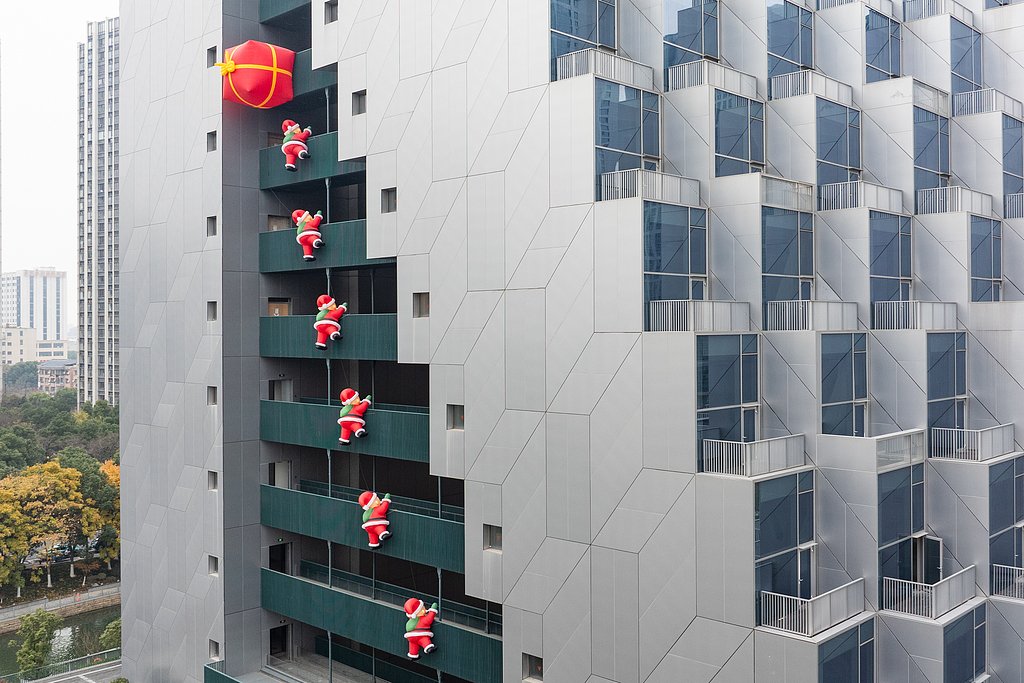 A high-rise building in Hangzhou sees large inflatable Santa Clauses “climbing the walls to deliver gifts”