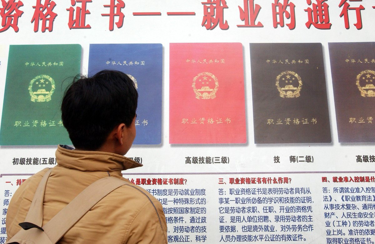 An unemployed man looks at available work certifications being advertised, China’s certification craze