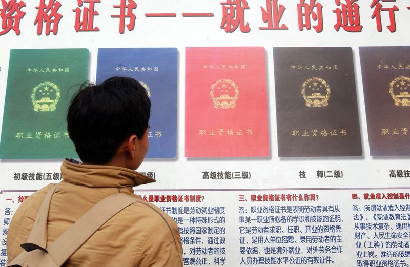 An unemployed man looks at available work certifications being advertised, China’s certification craze