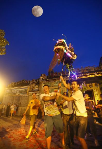 Locals perform the “fire dragon dance,” a Mid-Autumn Festival custom in Xiamao village, Guangdong province, in 2014 (VCG)