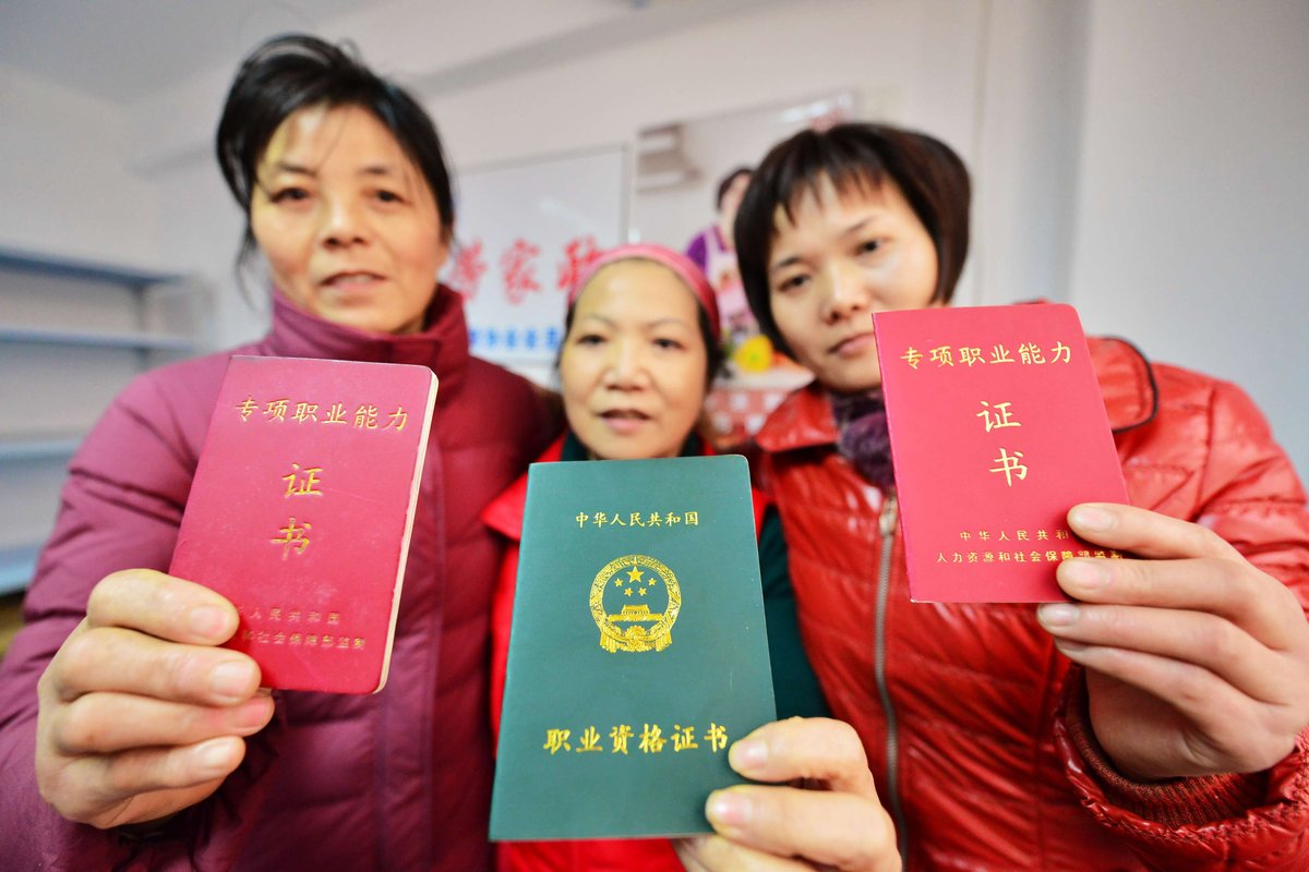 Three yuesao display their professional skills certificates. The middle certificate is for advanced postpartum care