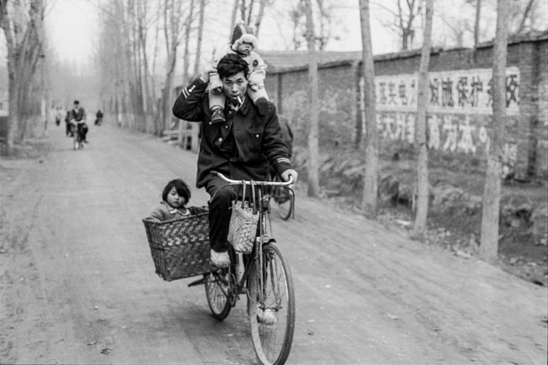 A man riding with kids to visit relatives in Henan province 1994