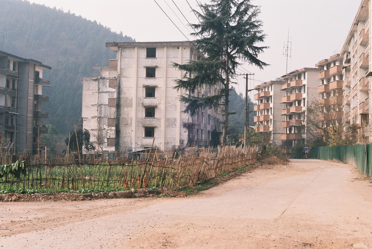 Former factory workers remain and use the old residential compound for farming, Yi ethnicity artist in china