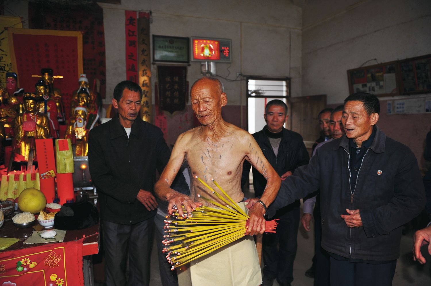 Performers of “kissing the burning incense,” mostly men in their 60s and 70s, snuff out the flames with their fingers one by one