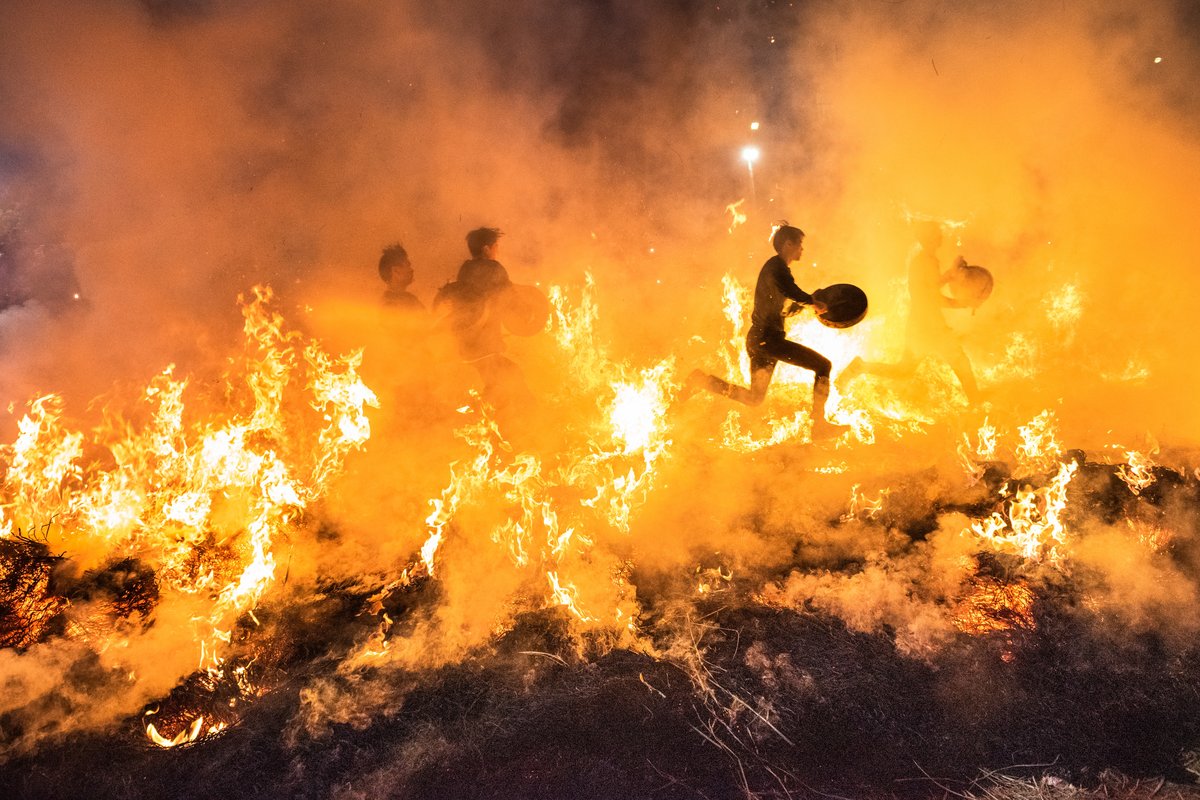 The drum and gong players charged across the fiery field first