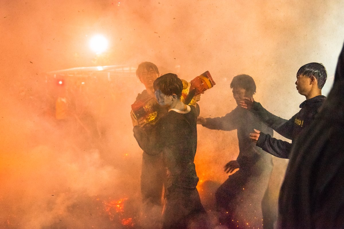 Young men are fighting to carry the statue through fire, believing it would bring them good luck